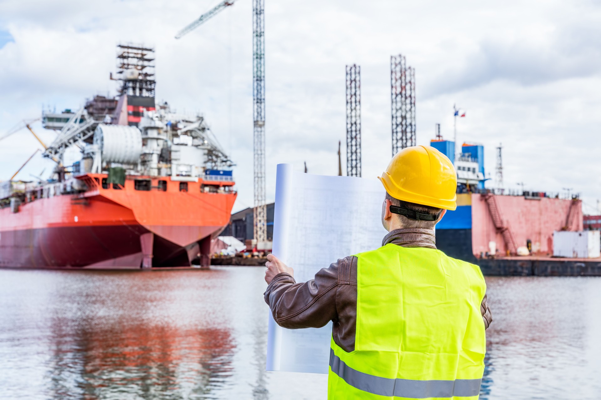 Shipbuilding engineer checking documents at the dock side in a port.